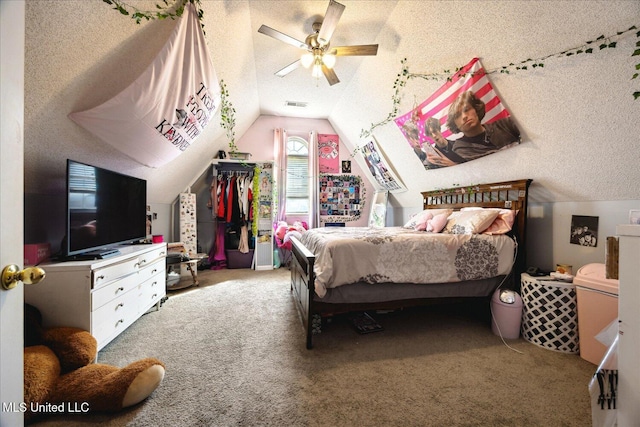 carpeted bedroom featuring ceiling fan, visible vents, vaulted ceiling, and a textured ceiling