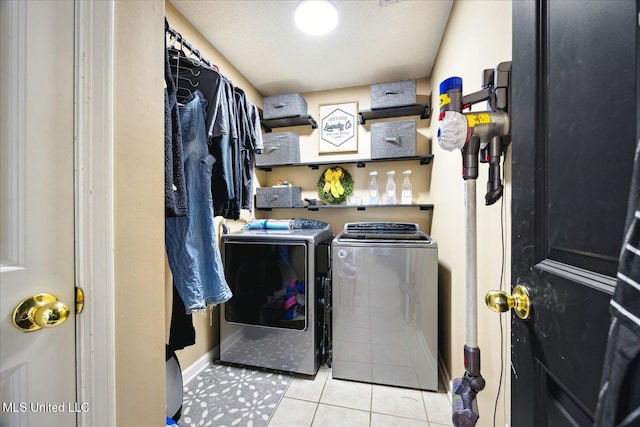 laundry area featuring laundry area, washer and clothes dryer, baseboards, and tile patterned floors