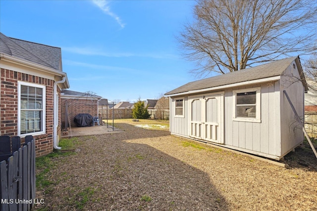 view of yard featuring a patio area, an outdoor structure, a fenced backyard, and a shed