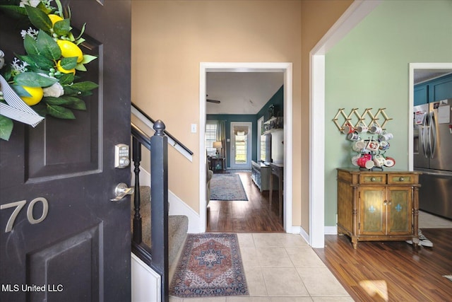 foyer entrance with stairway, baseboards, and wood finished floors