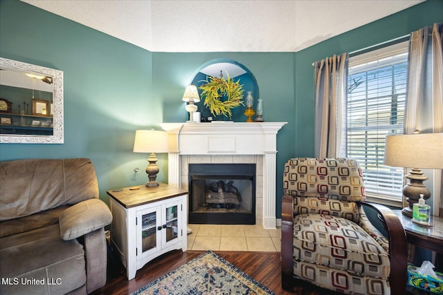 sitting room with a textured ceiling, a fireplace, and wood finished floors