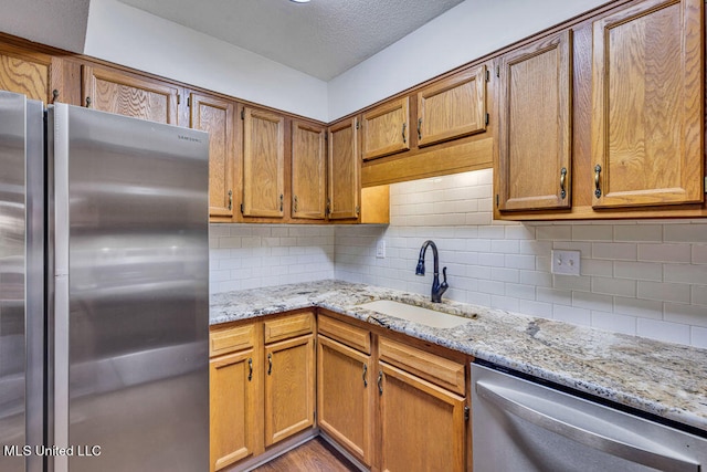 kitchen with light hardwood / wood-style floors, appliances with stainless steel finishes, sink, and decorative backsplash