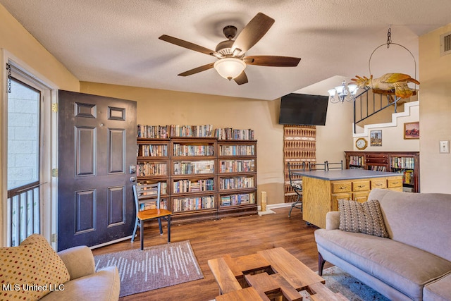 living room with ceiling fan, a textured ceiling, and hardwood / wood-style floors