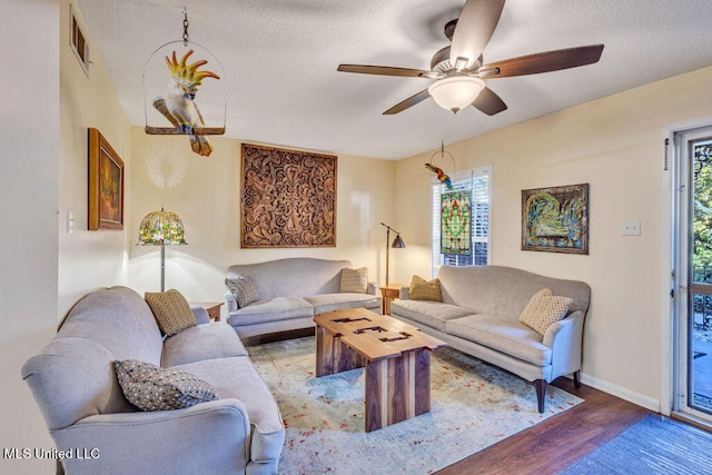 living room featuring hardwood / wood-style floors, a textured ceiling, plenty of natural light, and ceiling fan