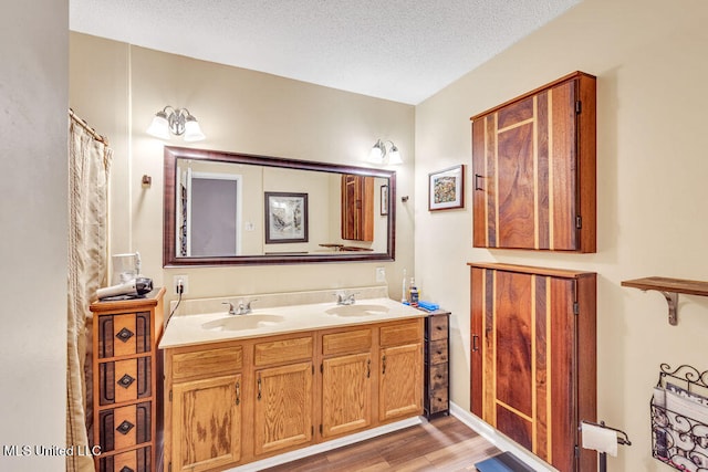 bathroom featuring vanity, a textured ceiling, and wood-type flooring