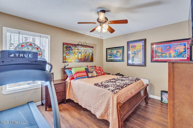 bedroom featuring dark hardwood / wood-style floors, a textured ceiling, and ceiling fan