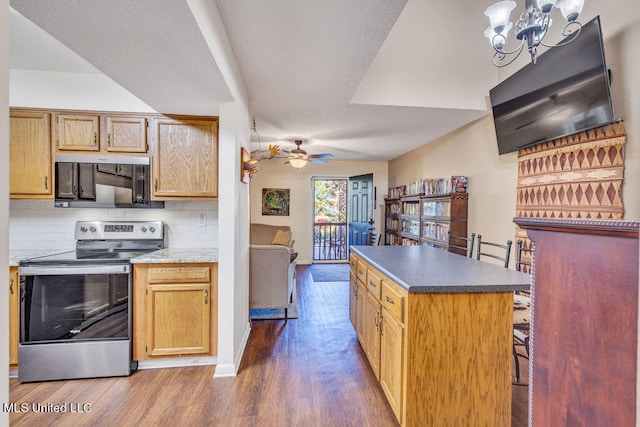 kitchen with backsplash, hardwood / wood-style floors, decorative light fixtures, ceiling fan with notable chandelier, and electric stove