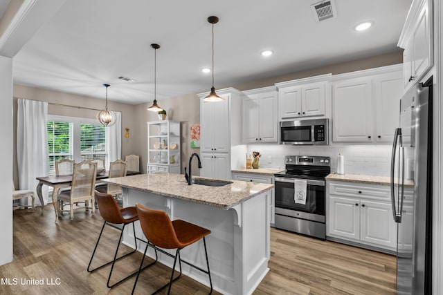 67 E Andover, Hattiesburg, MS 39402 - kitchen with stainless steel appliances, white cabinets, decorative backsplash, light wood-type flooring, and recessed lighting