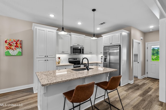 67 E Andover, Hattiesburg, MS 39402 - kitchen with stainless steel appliances, wood finished floors, white cabinetry, light stone counters, and recessed lighting