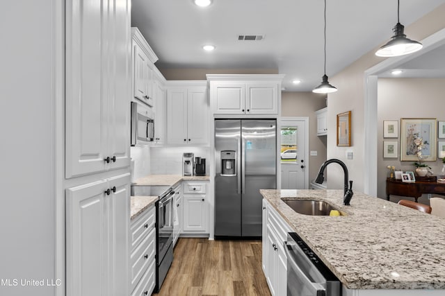67 E Andover, Hattiesburg, MS 39402 - kitchen featuring appliances with stainless steel finishes, white cabinetry, light wood finished floors, recessed lighting, and a center island with sink