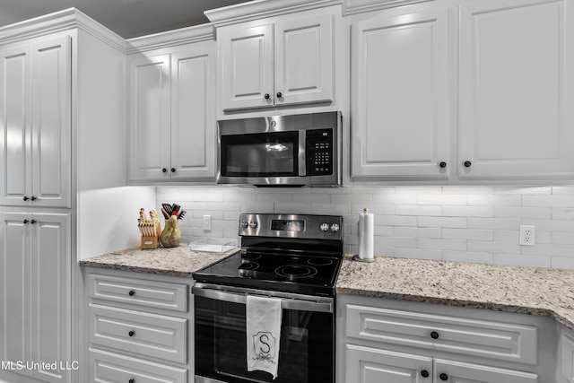 67 E Andover, Hattiesburg, MS 39402 - kitchen with appliances with stainless steel finishes, white cabinets, decorative backsplash, and light stone counters