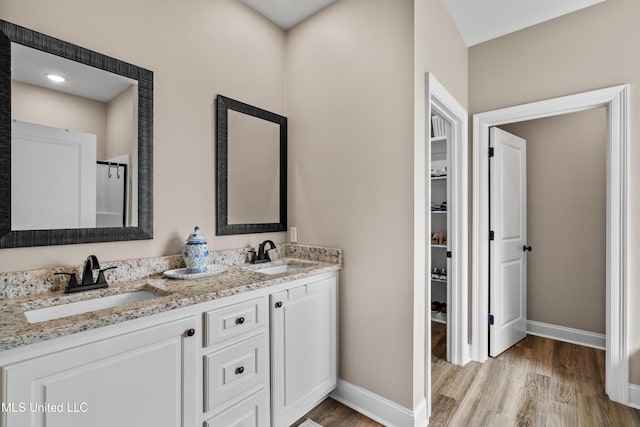 67 E Andover, Hattiesburg, MS 39402 - bathroom with wood finished floors, double vanity, and a walk in closet