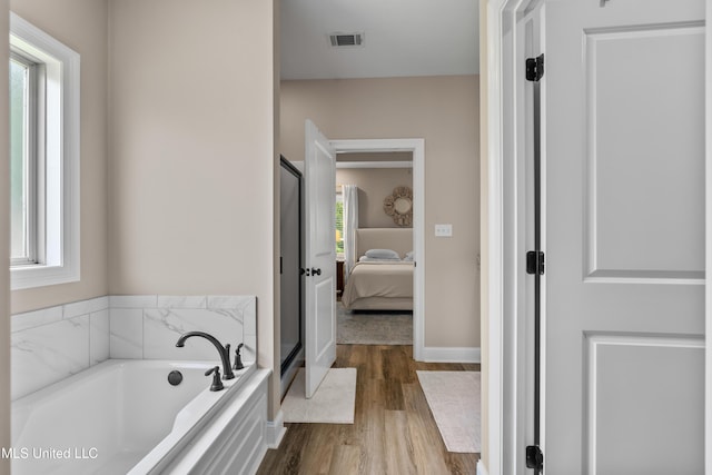 67 E Andover, Hattiesburg, MS 39402 - ensuite bathroom featuring wood finished floors, a bath, healthy amount of natural light, and a stall shower
