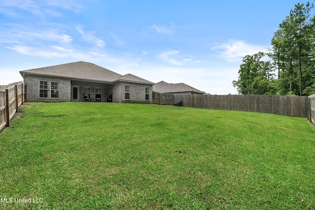 67 E Andover, Hattiesburg, MS 39402 - rear view of property featuring a fenced backyard, brick siding, and a shingled roof