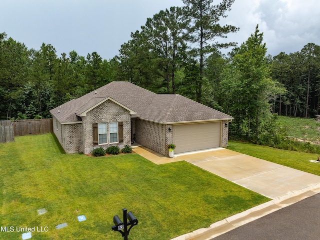 67 E Andover, Hattiesburg, MS 39402 - single story home featuring brick siding, an attached garage, concrete driveway, a shingled roof, and a forest view