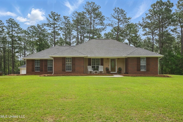 ranch-style house with covered porch, brick siding, a front yard, and roof with shingles