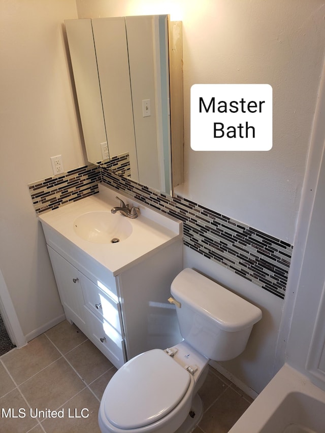 bathroom featuring tile patterned floors, vanity, toilet, and tasteful backsplash