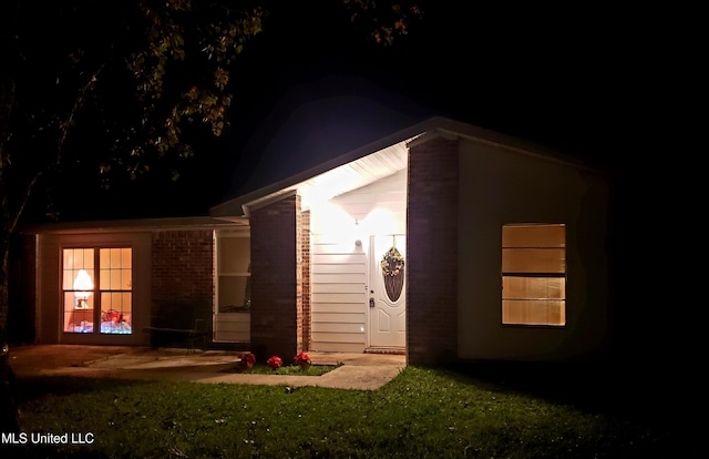 back house at twilight with a lawn