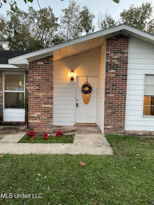 doorway to property featuring a yard