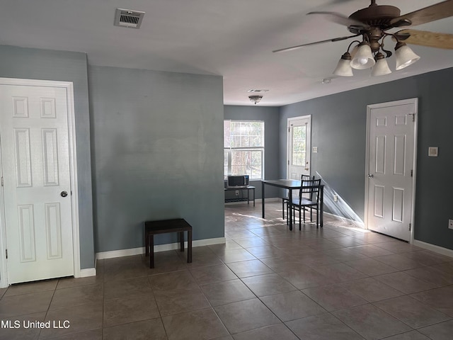 unfurnished dining area featuring tile patterned flooring and ceiling fan