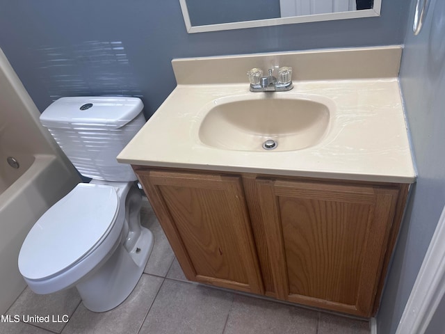 bathroom with tile patterned flooring, a bath, vanity, and toilet