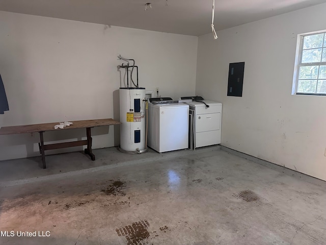 garage featuring electric panel, water heater, and independent washer and dryer