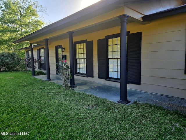 view of exterior entry featuring a lawn