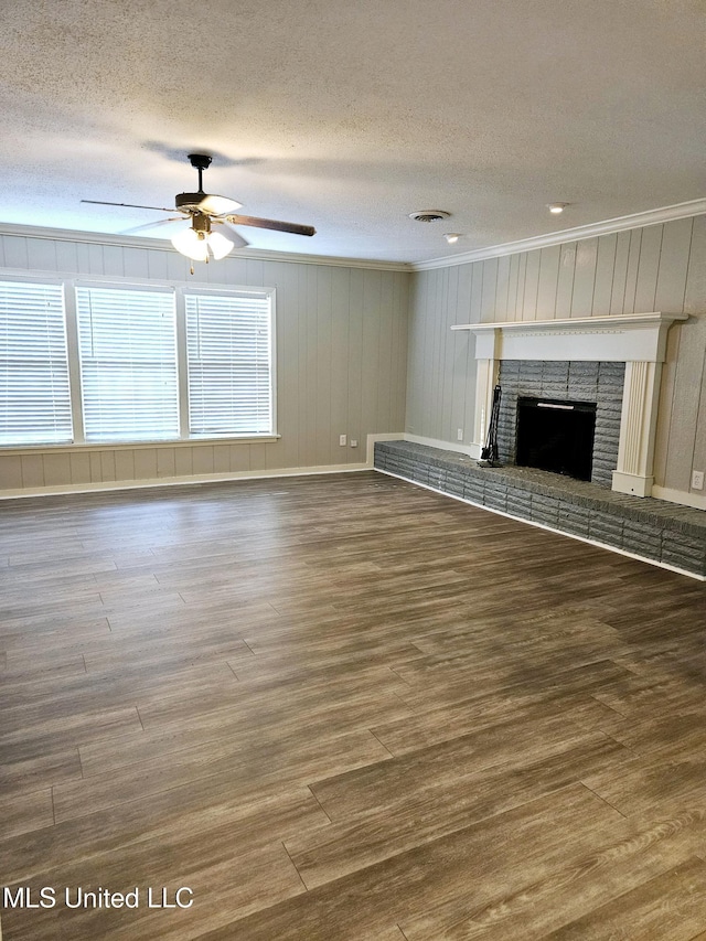 unfurnished living room featuring crown molding, a fireplace, a textured ceiling, a ceiling fan, and wood finished floors