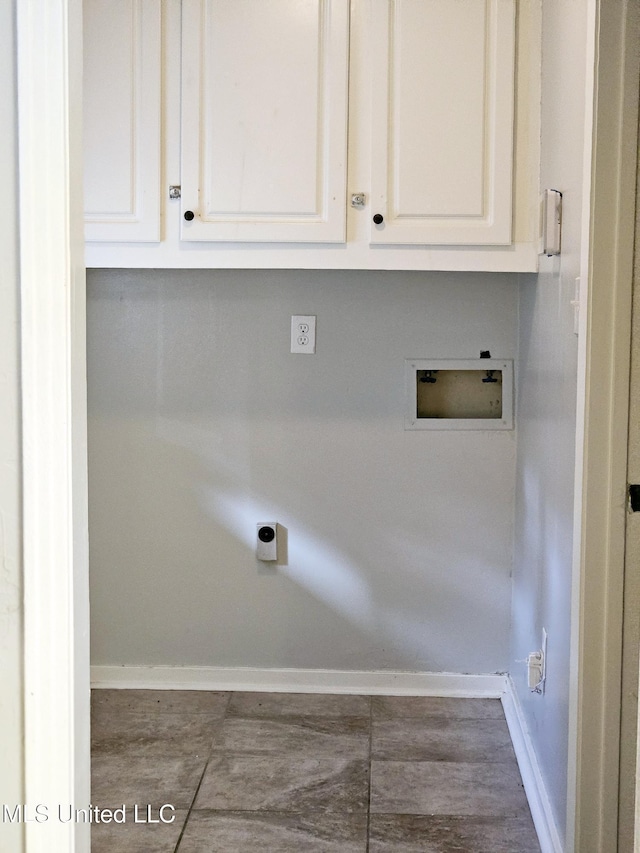 clothes washing area featuring washer hookup, baseboards, and cabinet space
