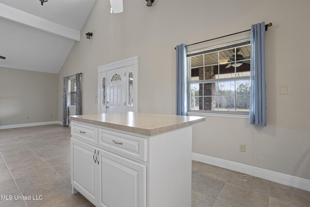 kitchen featuring baseboards, ceiling fan, light countertops, and white cabinets