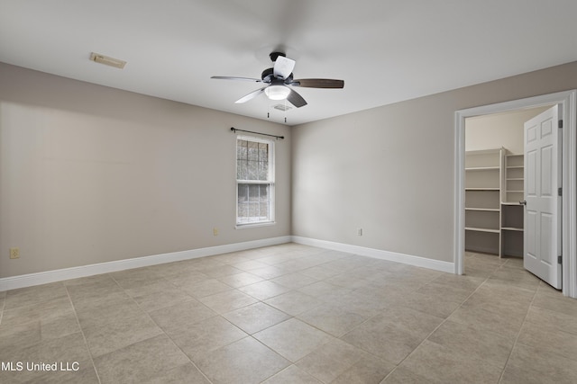unfurnished room with baseboards, light tile patterned flooring, and a ceiling fan