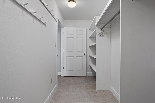spacious closet featuring light tile patterned floors