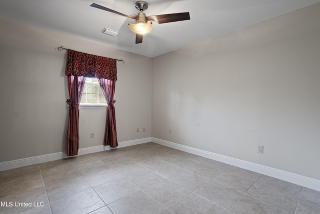 spare room featuring baseboards, visible vents, and ceiling fan