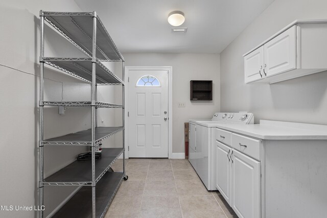 laundry area featuring baseboards, light tile patterned flooring, visible vents, cabinet space, and washing machine and dryer