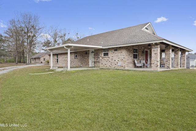 farmhouse-style home featuring a patio area, brick siding, a front lawn, and roof with shingles