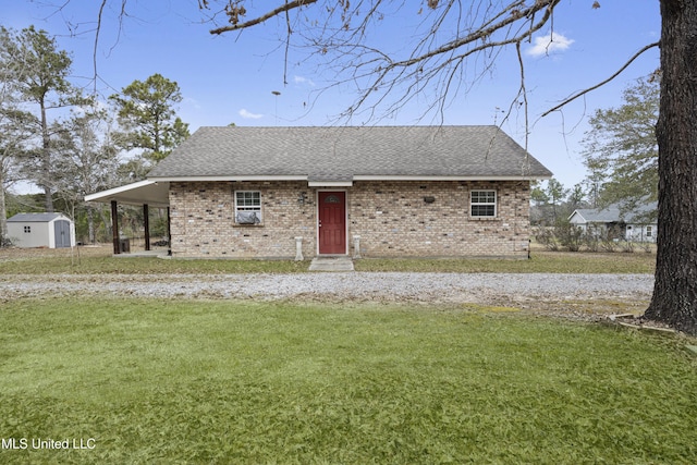 view of front of property with brick siding, a front lawn, an outdoor structure, and a shed