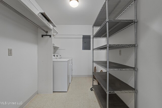 laundry room featuring electric panel, baseboards, laundry area, light floors, and washing machine and dryer