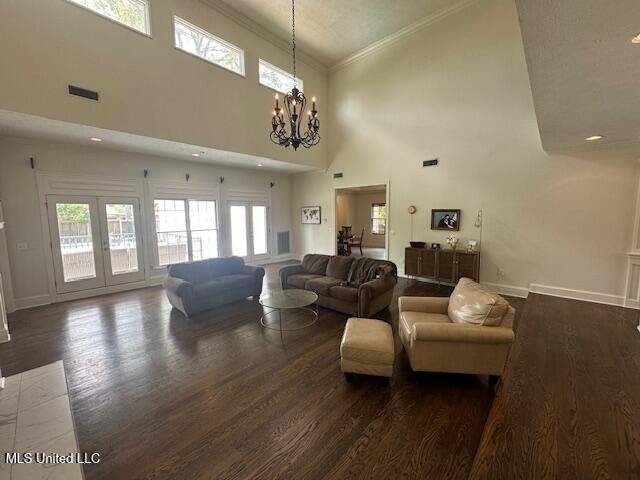 117 Peninsula Dr, Brandon, MS 39047 - living room featuring a notable chandelier, wood finished floors, baseboards, visible vents, and ornamental molding
