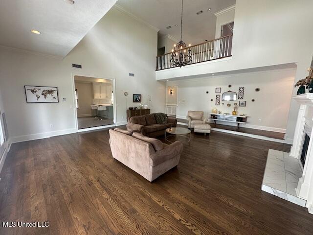 117 Peninsula Dr, Brandon, MS 39047 - living room featuring a fireplace with flush hearth, visible vents, baseboards, wood finished floors, and an inviting chandelier