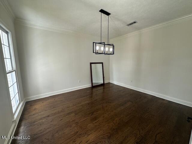 117 Peninsula Dr, Brandon, MS 39047 - spare room featuring visible vents, crown molding, dark wood-type flooring, and a chandelier