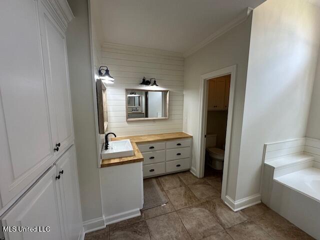 117 Peninsula Dr, Brandon, MS 39047 - full bath with crown molding, toilet, vanity, a garden tub, and wood walls