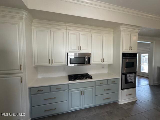 117 Peninsula Dr, Brandon, MS 39047 - kitchen with gray cabinetry, ornamental molding, backsplash, and stainless steel appliances