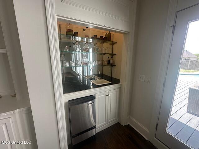 117 Peninsula Dr, Brandon, MS 39047 - bar featuring baseboards, wet bar, a sink, dark wood-style floors, and fridge