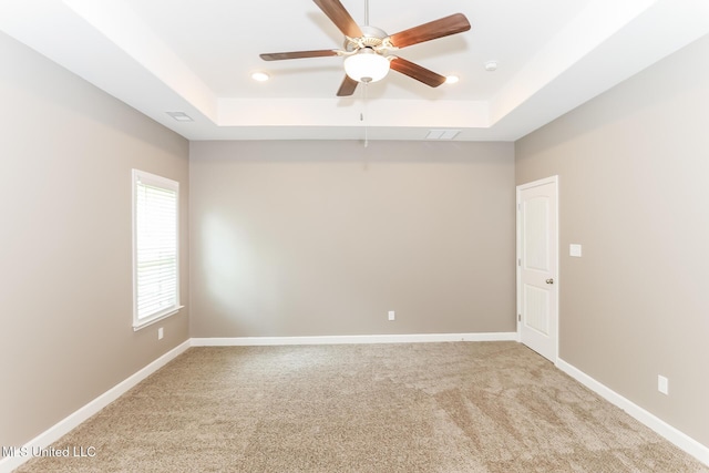 unfurnished room featuring a tray ceiling, ceiling fan, light carpet, and recessed lighting