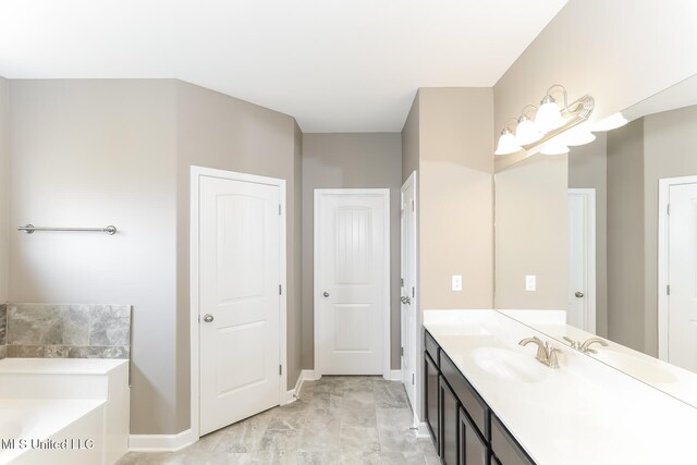 full bath with a bath, baseboards, and vanity
