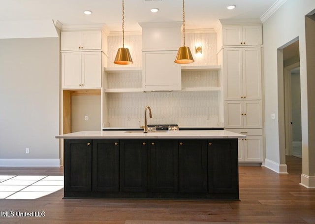 kitchen featuring ornamental molding, sink, pendant lighting, a center island with sink, and white cabinets