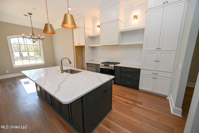 kitchen with white cabinetry, a kitchen island with sink, and sink