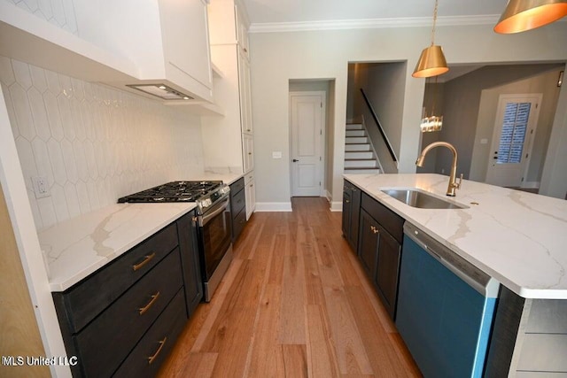 kitchen featuring sink, ornamental molding, appliances with stainless steel finishes, decorative light fixtures, and white cabinetry