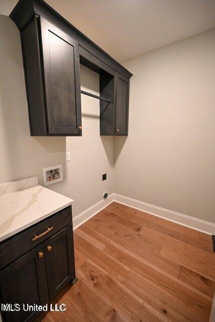 laundry area with washer hookup, cabinets, and light wood-type flooring