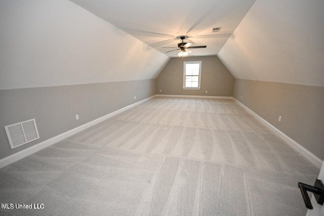 additional living space featuring ceiling fan, light colored carpet, and vaulted ceiling